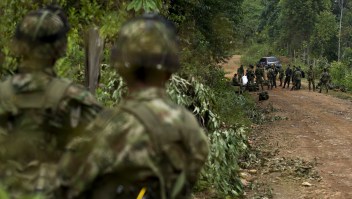 Soldados colombianos vigilan el traslado de los cuerpos sin vida de 11 militares luego del ataque a un grupo del Ejército por parte de la guerrilla de las Farc, el 15 de abril de 2015 en el departamento de Cauca, al suroccidente colombiano. (Crédito: LUIS ROBAYO/AFP/Getty Images)
