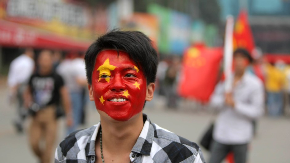 A football fan with his face painted like a Chinese national flag gets ready to watch the qualifier between China and Singapore for the 2014 World Cup Brazil, in Kunming, in southwest China's Yunnan province on September 2, 2011. China beat Singapore 2-1. AFP PHOTO (Photo credit should read STR/AFP/Getty Images)