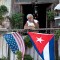 Un cubano saluda desde su balcón decorado con las banderas de Cuba y Estados Unidos en La Habana el 16 de enero de 2015 (Crédito: YAMIL LAGE/AFP/Getty Images)