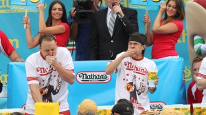 Joey Chestnut (izq) y el nuevo campeón, Matt Stonie, en un mano a mano comiendo ‘hoy dogs’ el pasado 4 de julio en Coney Island. (Crédito: Tina Fineberg/AFP)