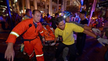 Thai rescue workers carry an injured person after a bomb exploded outside a religious shrine in central Bangkok late on August 17, 2015 killing at least 10 people and wounding scores more. Body parts were scattered across the street after the explosion outside the Erawan Shrine in the downtown Chidlom district of the Thai capital. AFP PHOTO / PORNCHAI KITTIWONGSAKUL (Photo credit should read PORNCHAI