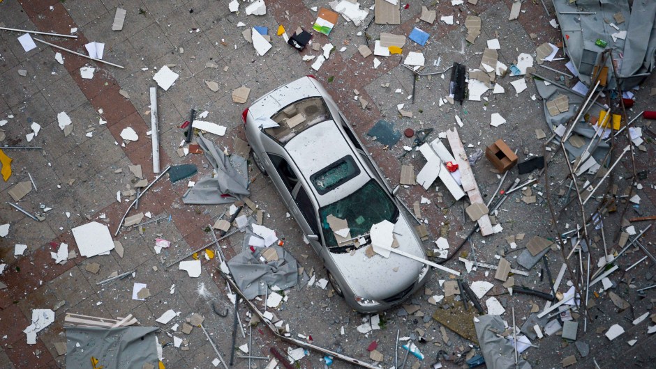 A damaged car is covered with shattered wall tiles and window parts at the site of the massive explosions in Tianjin on August 13, 2015. Enormous explosions in a major Chinese port city killed at least 44 people and injured more than 500, state media reported on August 13, leaving a devastated industrial landscape of incinerated cars, toppled shipping containers and burnt-out buildings. CHINA OUT AFP PHOTO (Photo credit should read STR/AFP/Getty Images)