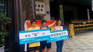 Chen Qiuyan y sus amigos afuera de un tribunal en Cantón el 29 de julio de 2015. El cartel de la izquierda lee: "Buscando justicia. Las personas gay pueden casarse en Estados Unidos, pero los libros de texto los estigmatizan en China".