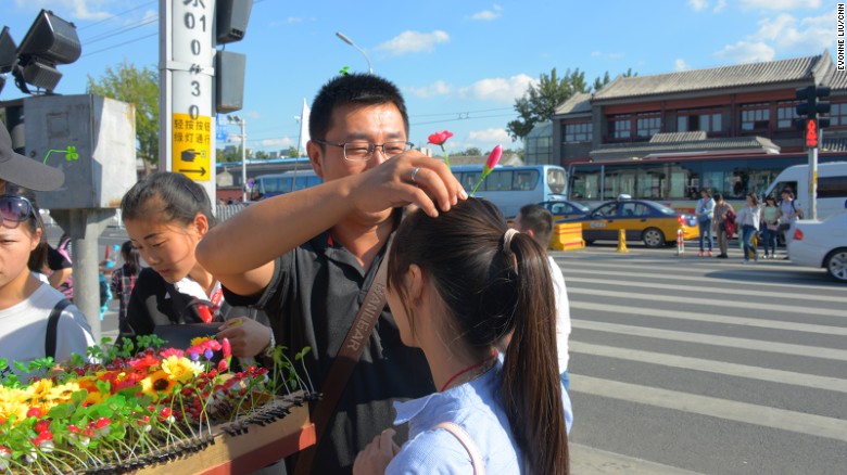 Turistas emocionados se prueban sus ganchos en Nanluoguxiang, un popular sitio turístico en Beijing.