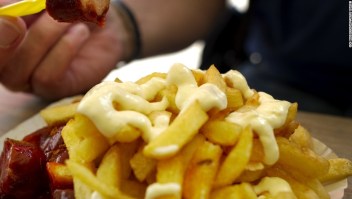 A man eats "curry wurst and pommes" a German sausage with French Fries and mayonnaise from a street vendor in Berlin on 25 August , 2011. The dish is second only to the Doner kebab as the German's favorite fast food. AFP PHOTO / ODD ANDERSEN (Photo credit should read ODD ANDERSEN/AFP/Getty Images)