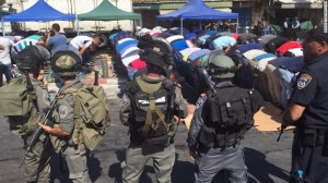 Fuerzas de seguridad Israelíes rodean fieles musulmanes durante la oración del Viernes.