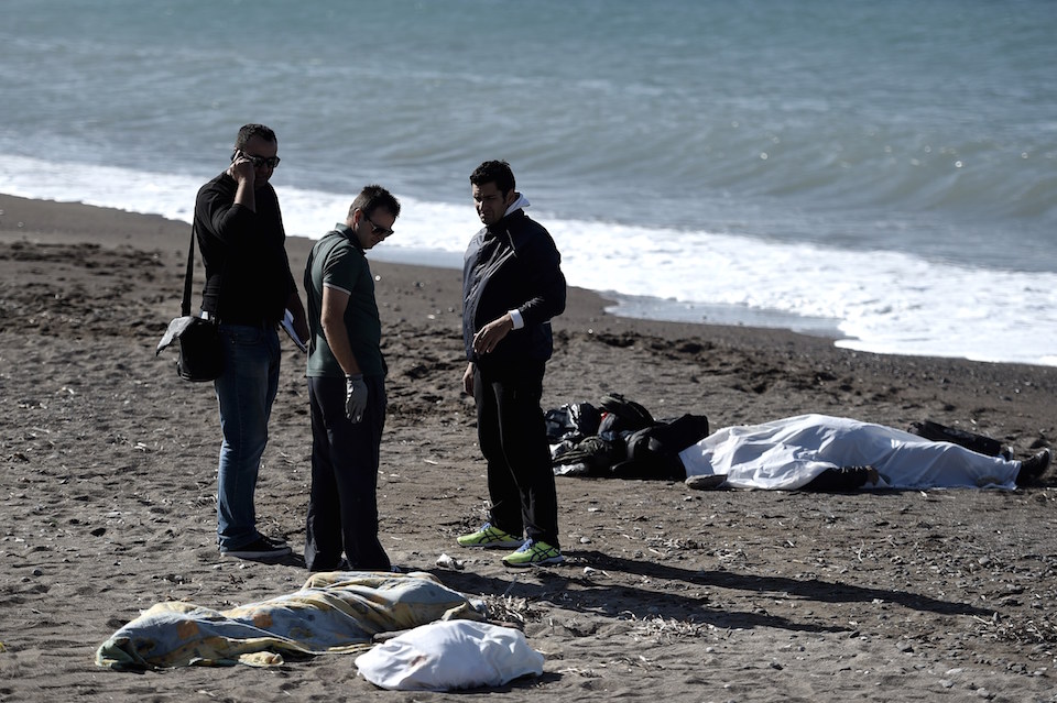 Oficiales de policía cerca a los cuerpos sin vida de tres niños y un hombre que se ahogaron al intentar cruzar el mar Egeo desde Turquía,hacia la isla griega de Lesbos, el 30 de octubre de 2015. (Crédito: ARIS MESSINIS/AFP/Getty Images) 