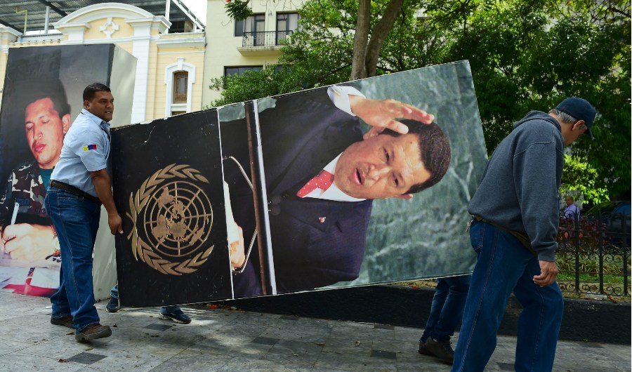 A National Assembly employee helps to remove from the building a picture of late President Hugo Chavez, in Caracas on January 6, 2016. Venezuela's opposition on Tuesday broke the government's 17-year grip on the legislature and vowed to force out President Nicolas Maduro despite failing for the time being to clinch its hoped-for 'supermajority.' AFP PHOTO/RONALDO SCHEMIDT / AFP / RONALDO SCHEMIDT (Photo credit should read RONALDO SCHEMIDT/AFP/Getty Images)