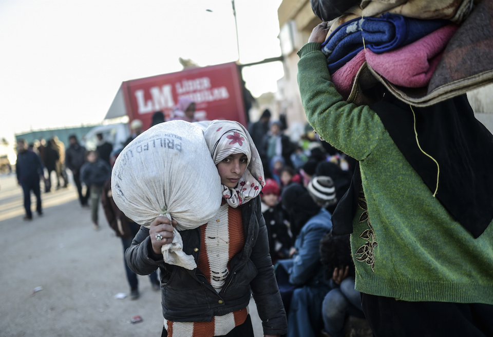 Una joven refugiada siria se apresura a llegar a la zona fronteriza con Turquía. Cerca de 40.000 mil personas han salido de Aleppo en días recientes. (Crédito: BULENT KILIC/AFP/Getty Images).