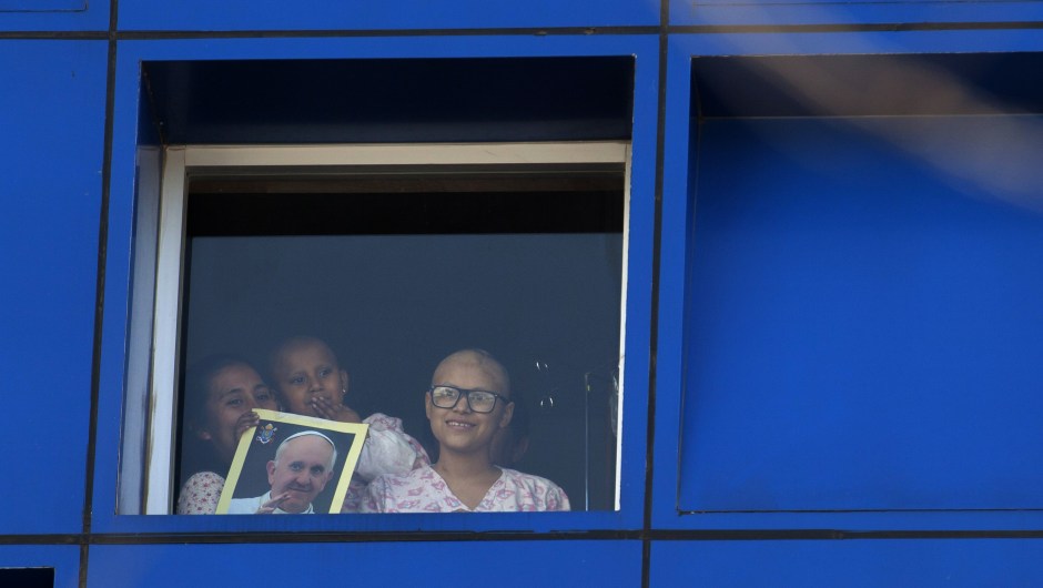 Patients from the Children Pediatric Hospital Federico Gomez watch from a widow the faithful waiting for the arrival of Pope Francis, in Mexico City on February 14, 2016. Pope Francis urged Mexicans on Sunday to turn their country into a land of opportunity where there is no need to emigrate or mourn victims "of the merchants of death."AFP PHOTO . AFP PHOTO /DIANA ULLOA / AFP / DIANA ULLOA (Photo credit should read DIANA ULLOA/AFP/Getty Images)