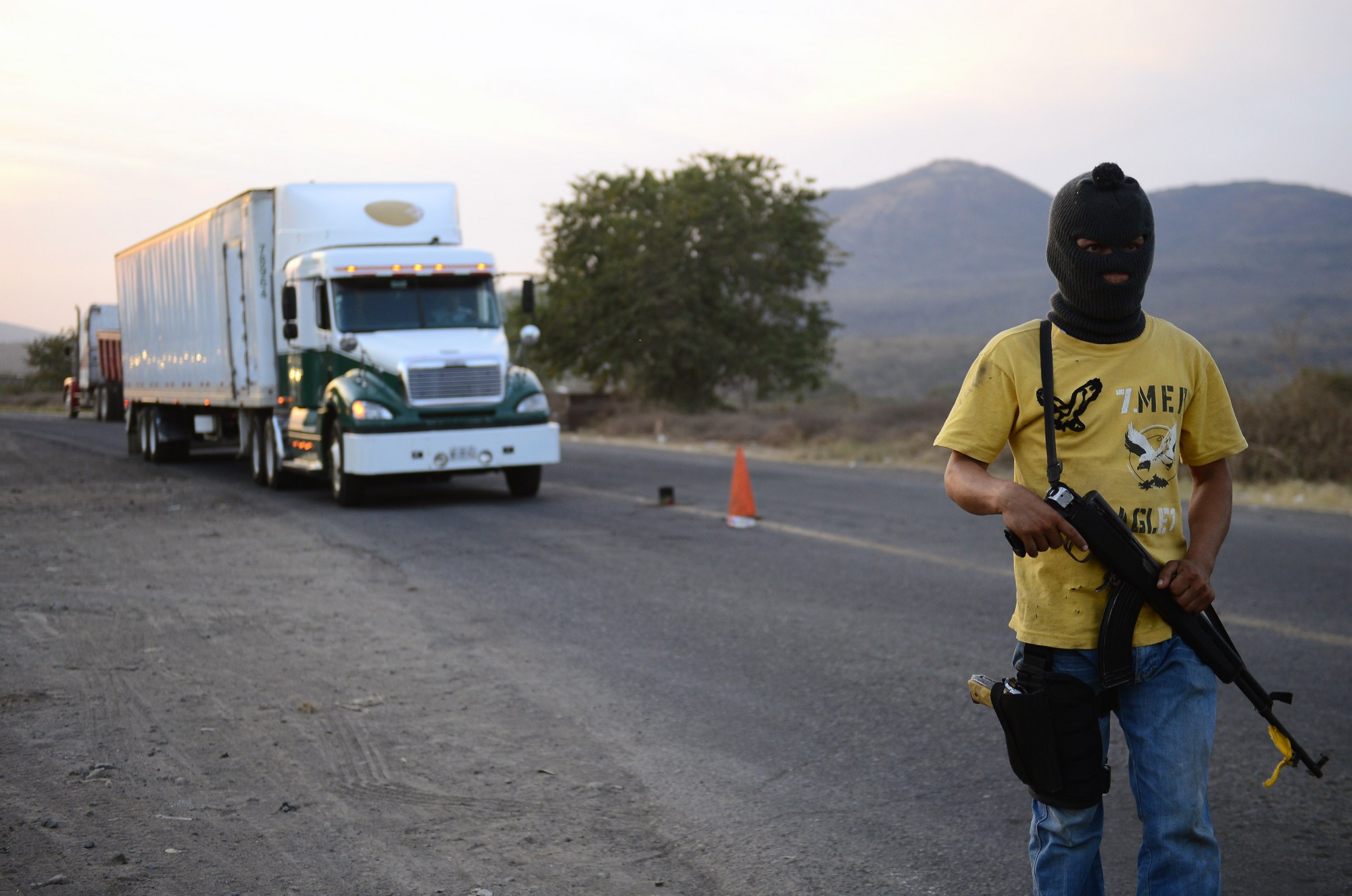 Un miembro de un grupo de autodefensa patrulla una carretera entre Tepalcatepec y Apatzingán, en el estado de Michoacán. Grupos de civiles tomaron las armas en 2014 en respuesta a la violencia causada por los cárteles de la droga. (Crédito: Alfredo Estrella/AFP/Getty Images)