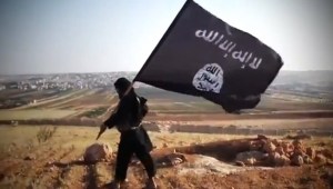 An image grab taken from a video uploaded on YouTube on August 23, 2013 allegedly shows a member of Ussud Al-Anbar (Anbar Lions), a Jihadist group affiliated to the Islamic State of Iraq and the Levant , Al-Qaeda's front group in Iraq, holding up the trademark black and white Islamist flag at an undisclosed location in Iraq's Anbar province. Attacks in Iraq killed 14 people including six soldiers on August 25, Iraqi officials said, amid a surge in violence authorities have so far failed to stem despite wide-ranging operations targeting militants. Arabic writing on the flag reads: "There is not God but God and Mohammed is the prophet of God." AFP PHOTO / YOUTUBE == RESTRICTED TO EDITORIAL USE - MANDATORY CREDIT "AFP PHOTO / YOUTUBE " - NO MARKETING NO ADVERTISING CAMPAIGNS - DISTRIBUTED AS A SERVICE TO CLIENTS FROM FROM ALTERNATIVE SOURCES, THEREFORE AFP IS NOT RESPONSIBLE FOR ANY DIGITAL ALTERATIONS TO THE PICTURE'S EDITORIAL CONTENT, DATE AND LOCATION WHICH CANNOT BE INDEPENDENTLY VERIFIED ==