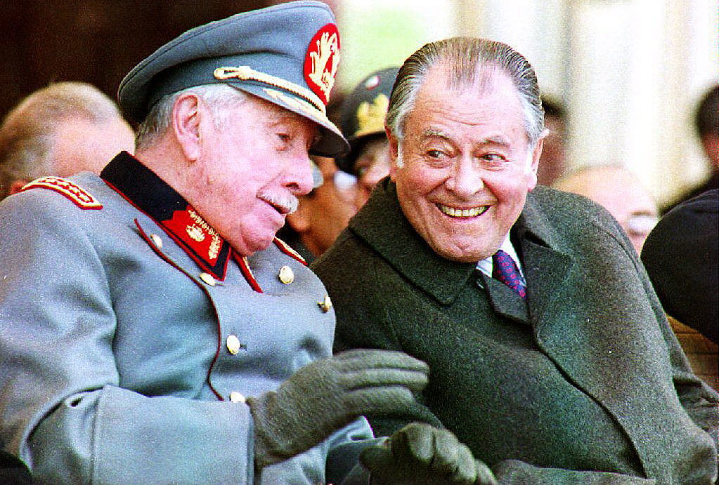 SANTIAGO, CHILE: Former Chilean President Gen. Augusto Pinochet (L), commander of the armed forces, talks with President Patricio Aylwin 09 July 1993 during the swearing-in of some 1,000 concripts into the army in Santiago, Chile. Both leaders are seeking a solution to demands for justice against 230 servcicemen accused of human rights abuses. (Photo credit should read CRIS BOURONCLE/AFP/Getty Images)