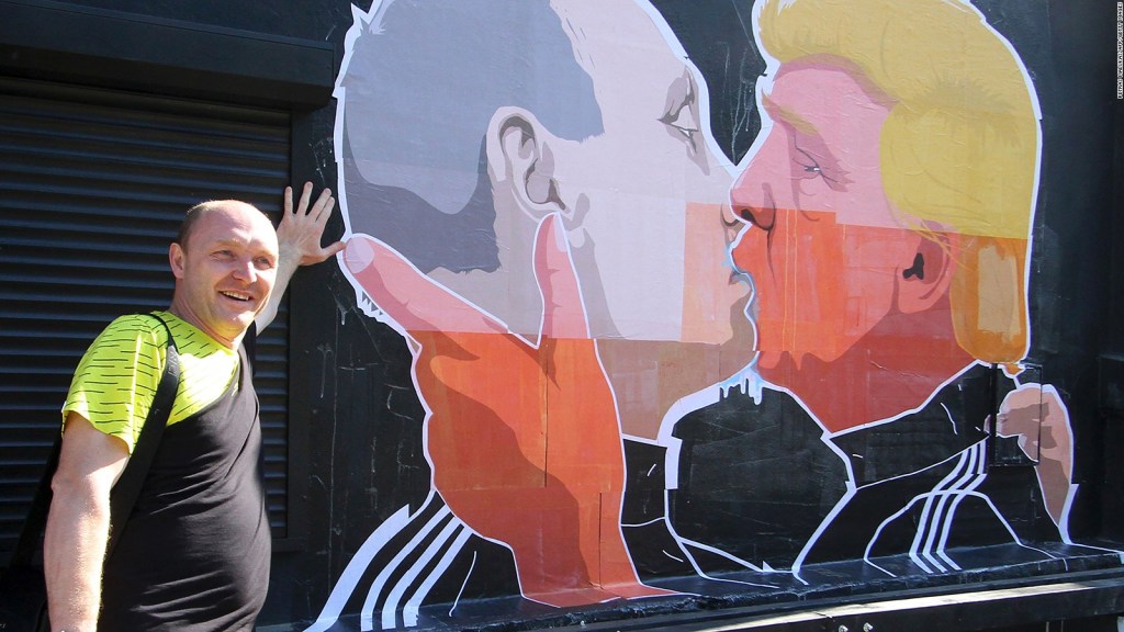 Dominykas Ceckauskas posa junto a un mural en la pared de su restaurante en Vilna, Lituania, que representa al candidato republicano Donald Trump saludando con un beso al presidente ruso, Vladimir Putin. Crédito: PETRAS MALUKAS/AFP/Getty Images