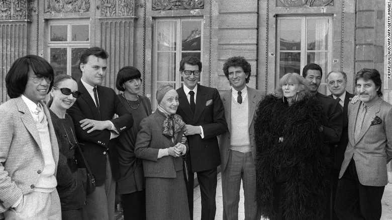 Sonia Rykiel (con abrigo de plumas negras) posa con el Ministro de Cultura francés Jack Lang (séptimo de izquierda a derecha) y sus contemporáneos de la moda en París en 1984.