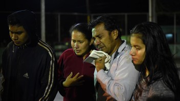 Un grupo de personas llora mientras observa cómo los rescatistas se llevan el cuerpo de uno de sus familiares que falleció en los deslizamientos en Guatemala. (JOHAN ORDONEZ/AFP/Getty Images)