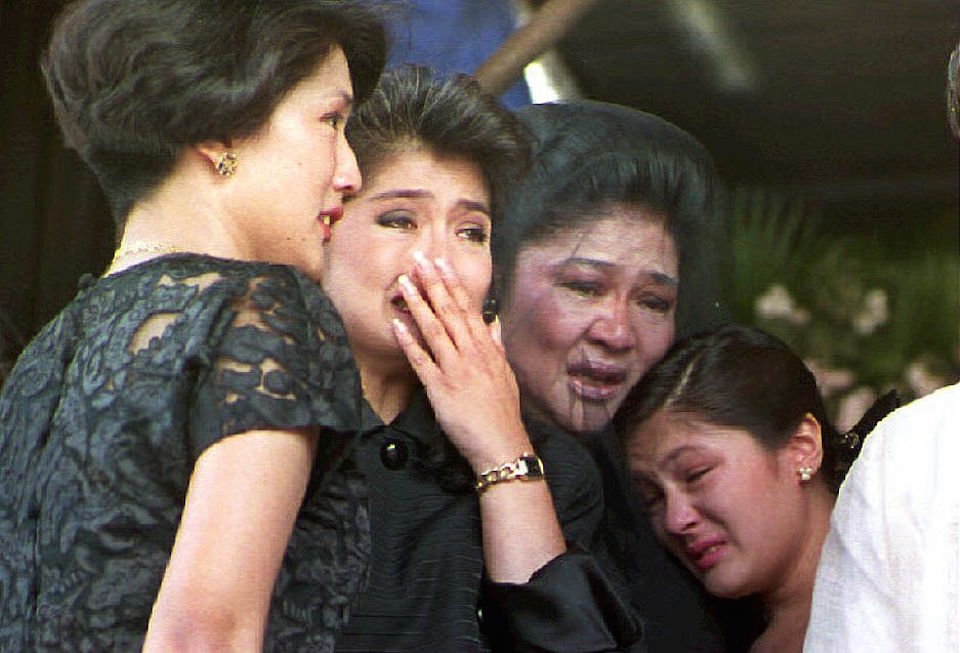 BATAC, PHILIPPINES: Former first lady Imelda Marcos (2nd R) and her children Irene Araneta (L), Imee Manotoc (C) and adopted daughter Aimee (R) weep 09 September 1993 during a public eulogy for Ferdinand Marcos in Batac, Philippines. Marcos' remains arrived 07 September in his northern Philippine hometown for final burial. (Photo credit should read ROMEO GACAD/AFP/Getty Images)
