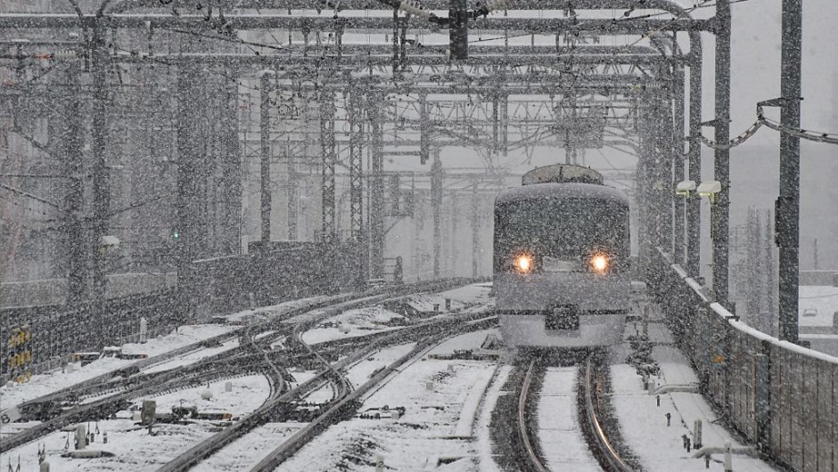A train approaches a station as snow falls in Tokyo on November 24, 2016. Tokyo woke up on November 24 to its first November snowfall in more than half a century, leaving commuters to grapple with train disruptions and slick streets. / AFP / KAZUHIRO NOGI (Photo credit should read