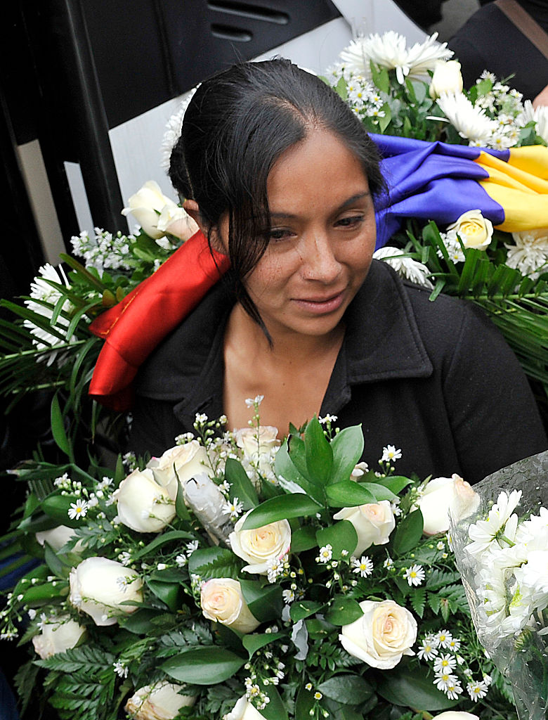 The mother of Yuliana - a seven-year-old girl who was raped, tortured and murdered - holds white flowers and a Colombian flag after a mass held in the victim's honour at the Santa Teresita church in Bogota, Colombia, on December 7, 2016. A seven-year-old girl was raped, tortured and murdered in Bogota this weekend, allegedly by a 38-year-old man who kidnapped the girl from her low-income neighborhood on the east side of the city and took her to a luxury apartment belonging to his family, the police said. The girl's body was found on the scene, showing signs of torture and sexual abuse. / AFP / GUILLERMO LEGARIA (Photo credit should read GUILLERMO LEGARIA/AFP/Getty Images)