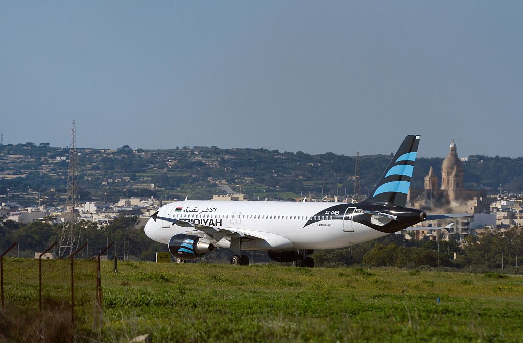 A picture taken on December 23, 2016 shows a hijacked Airbus A320 operated by Afriqiyah Airways after it landed at Luqa Airport, in Malta. A hijacked plane from Libya landed on the Mediterranean island of Malta on December 23 with 118 people including seven crew members on board, Malta's prime minister and government sources said. The Airbus A320 had been on a domestic Libyan route operated by Afriqiyah Airways from Sabha in the south to the capital Tripoli but was re-routed. / AFP / Matthew Mirabelli / Malta OUT (Photo credit should read MATTHEW MIRABELLI/AFP/Getty Images)