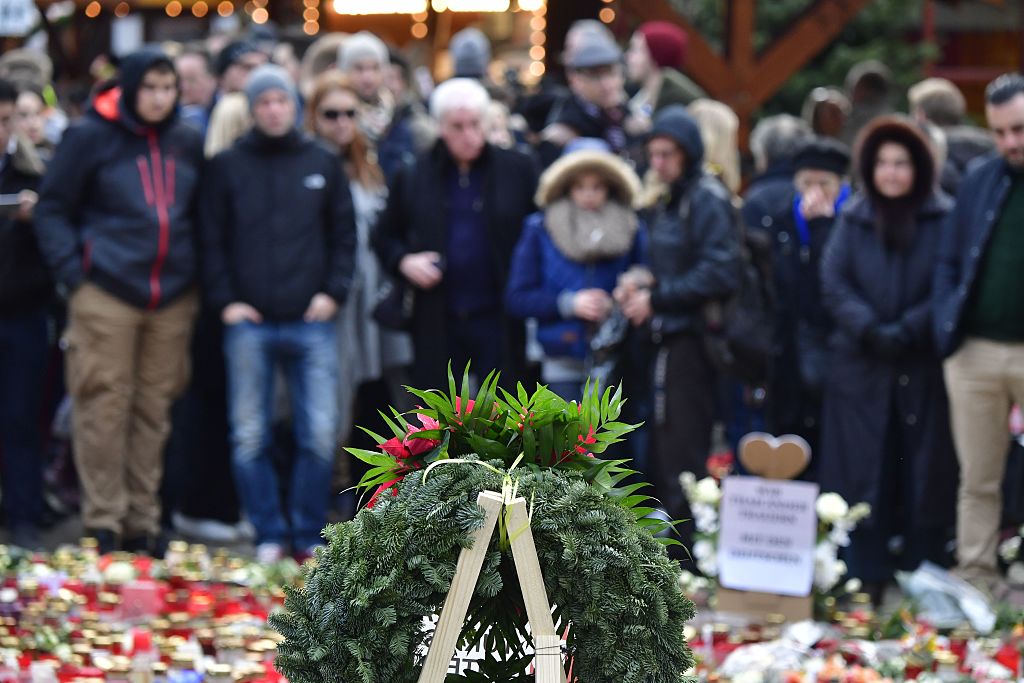 Un grupo de personas se reúne frente a un homenaje a las víctimas del ataque a Berlín. (JOHN MACDOUGALL/AFP/Getty Images)
