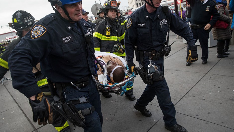 NEW YORK, NY - JANUARY 4: Members of the New York City Police Department and New York City Fire Department carry an injured person away from Atlantic Terminal, January 4, 2017 in the Brooklyn borough of New York City. A Long Island Railroad train derailed at Atlantic Terminal on Wednesday morning. (Photo by Drew Angerer/Getty Images)