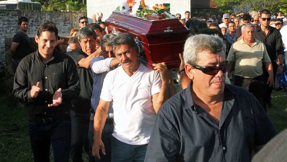 The sons of Paraguayan late football star Roberto Cabanas carry his coffin during his funeral in Pilar, Paraguay, on January 10, 2017. The striker -who died of a heart attack on the eve, aged 55- was a hero of top Argentine league side Boca Juniors and played alongside Brazilian legend Pele for the New York Cosmos in the 1980s. / AFP / STR (Photo credit should read STR/AFP/Getty Images)