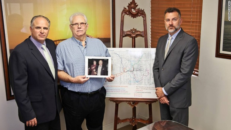 Antonio Caballero (c) con sus abogados y sosteniendo una foto de sus padres. 