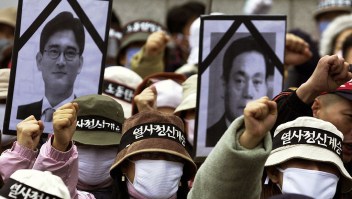 EOUL, REPUBLIC OF KOREA: South Korean workers chant slogan and hold black ribbon pictures of Lee Kun Hee (R) Chairman of the Samsung Group and his son Lee Jae-Yong (L) during a protest rally in Seoul, 12 November 2003. Tens of thousands of workers launched a one-day nationwide strike Wednesday as militant labor union leaders violated a police ban to stage a protest rally against government policy. The Korean Confederation of Trade Unions (KCTU) said some 150,000 workers joined the stoppage at 120 workplaces, including South Korea's largest auto company, Hyundai Motor, in the southern city of Ulsan.The labor ministry said the walkout had no major impact on the economy, saying it 44,000 workers from 77 metal, textile and chemical firms across the country.AFP PHOTO/JUNG YEON-JE (Photo credit should read JUNG YEON-JE/AFP/Getty Images)