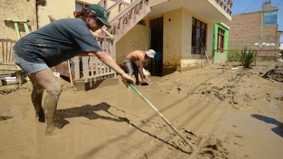 Local residents of the town of Huarmey, 300 kilometres north of Lima, try to get rid of muddy water on March 19, 2017 after a flash flood hit the evening before. The El Nino climate phenomenon is causing muddy rivers to overflow along the entire Peruvian coast, isolating communities and neighbourhoods. Thousands have been affected since January, and 72 people have died. Most cities face water shortages as water lines have been compromised by mud and debris. / AFP PHOTO / CRIS BOURONCLE (Photo credit should read CRIS BOURONCLE/AFP/Getty Images)