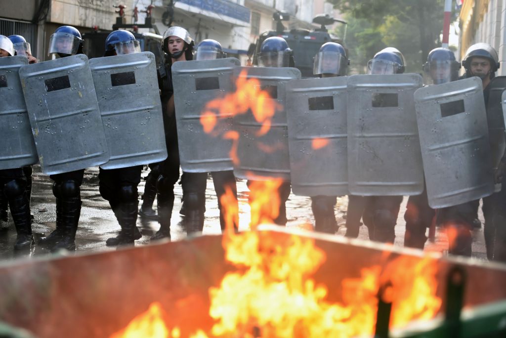 Riot police agents holding shields crack down on a protest against the approval of a constitutional amendment for presidential reelection, outside Congress in Asuncion, on March 31, 2017. Ruling Colorado party senators and their allies, in a so-called "parallel Senate", unexpectedly approved an amendment Friday that would allow President Horacio Cartes to run for reelection in 2018, triggering protests that led to clashes between opposition demonstrators and the police. / AFP PHOTO / NORBERTO DUARTE (Photo credit should read NORBERTO DUARTE/AFP/Getty Images)
