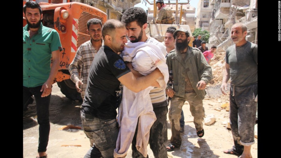 The father of a three-month old girl whose body was pulled out of the rubble weeps as he approaches the rescuer to carry her following a barrel bomb strike said to be launched by Syrian government forces on May 26, 2014 in the northern Syrian city of Aleppo in which serveral people were reported killed or wounded. Syrian President Bashar al-Assad, facing two little-known challengers in a June 3 presidential election, is widely expected to clinch a third seven-year term despite Syria's civil war, which has killed more than 160,000 people. AFP PHOTO / BARAA AL-HALABI (Photo credit should read BARAA AL-HALABI/AFP/Getty Images)