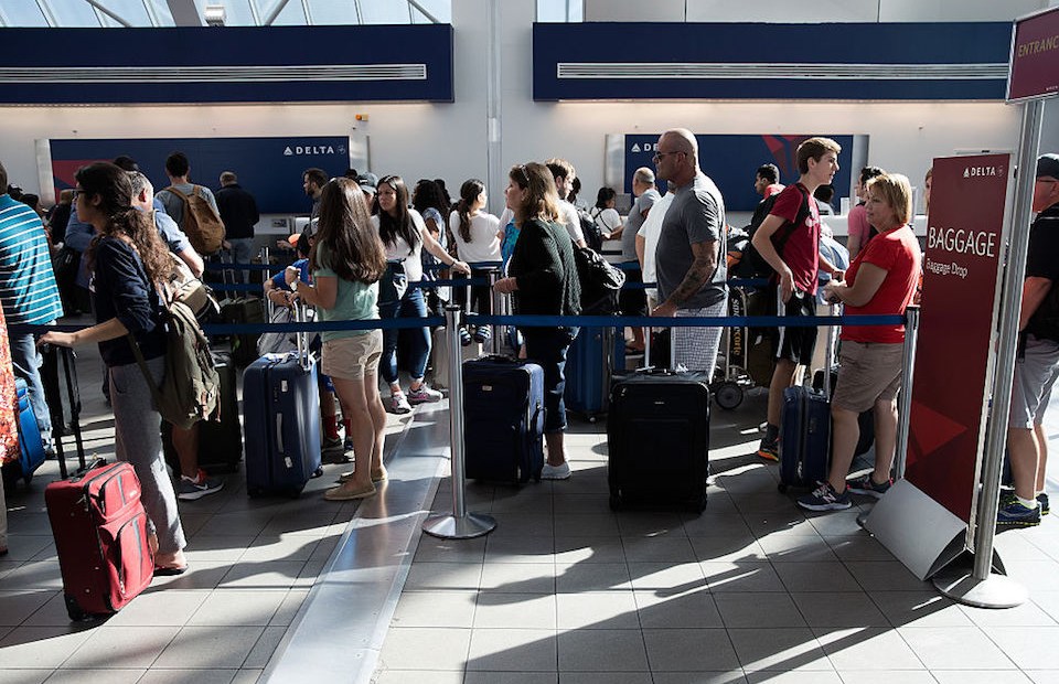 NEW YORK, NY - AUGUST 8: Travelers wait in line at the Delta baggage drop at LaGuardia Airport , August 8, 2016 in the Queens borough of New York City. Delta flights around the globe were grounded and delayed on Monday morning due to a system outage. (Photo by Drew Angerer/Getty Images)