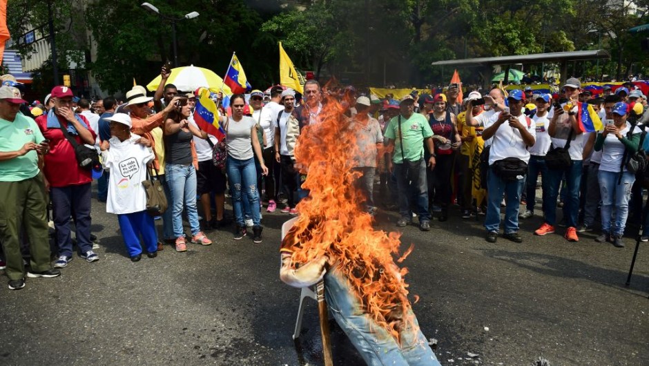 Demonstrators burn an effigy of President Nicolas Maduro during a protest at the east side of Caracas on April 19, 2017. Venezuela braced for rival demonstrations Wednesday for and against President Nicolas Maduro, whose push to tighten his grip on power has triggered waves of deadly unrest that have escalated the country's political and economic crisis. / AFP PHOTO / RONALDO SCHEMIDT (Photo credit should read RONALDO SCHEMIDT/AFP/Getty Images)