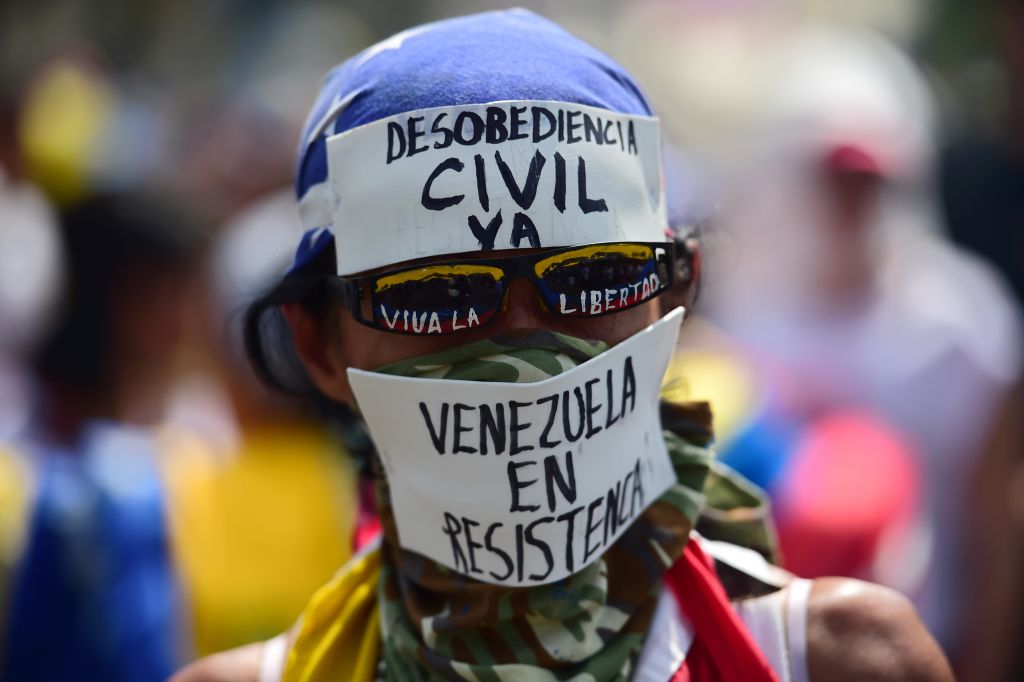 A demonstrator against President Nicolas Maduro's government calls to Civil Disobedience during a protest at the east side of Caracas on April 19, 2017. Venezuela braced for rival demonstrations Wednesday for and against President Nicolas Maduro, whose push to tighten his grip on power has triggered waves of deadly unrest that have escalated the country's political and economic crisis. / AFP PHOTO / RONALDO SCHEMIDT (Photo credit should read RONALDO SCHEMIDT/AFP/Getty Images)