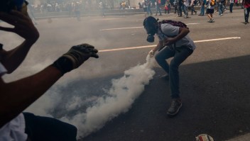 A demonstrator throws a tear gas canister back at the police during a rally against Venezuelan President Nicolas Maduro, in Caracas on April 19, 2017. Venezuela braced for rival demonstrations Wednesday for and against President Nicolas Maduro, whose push to tighten his grip on power has triggered waves of deadly unrest that have escalated the country's political and economic crisis. / AFP PHOTO / Juan BARRETO (Photo credit should read JUAN BARRETO/AFP/Getty Images)