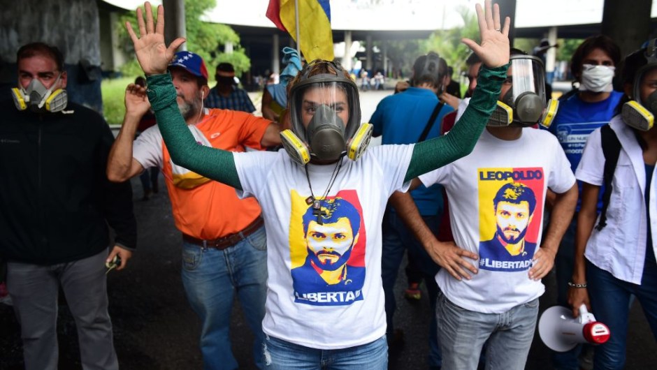 wears a gas mask during clashes with riot police ensueing a protest march in Caracas on April 26, 2017. Protesters in Venezuela plan a high-risk march against President Maduro Wednesday, sparking fears of fresh violence after demonstrations that have left 26 dead in the crisis-wracked country. / AFP PHOTO / RONALDO SCHEMIDT (Photo credit should read RONALDO SCHEMIDT/AFP/Getty Images)