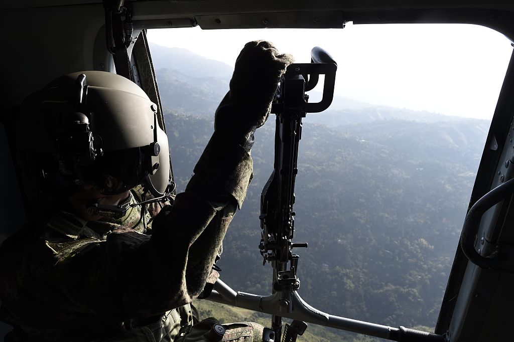 soldier remains on a helicoper as it overflies Valle del cauca department, Colombia on January 24, 2017. French President Francois Hollande visits Tuesday a FARC rebel disarmament zone in support of Colombia's peace process. / AFP / STEPHANE DE SAKUTIN (Photo credit should read STEPHANE DE SAKUTIN/AFP/Getty Images)