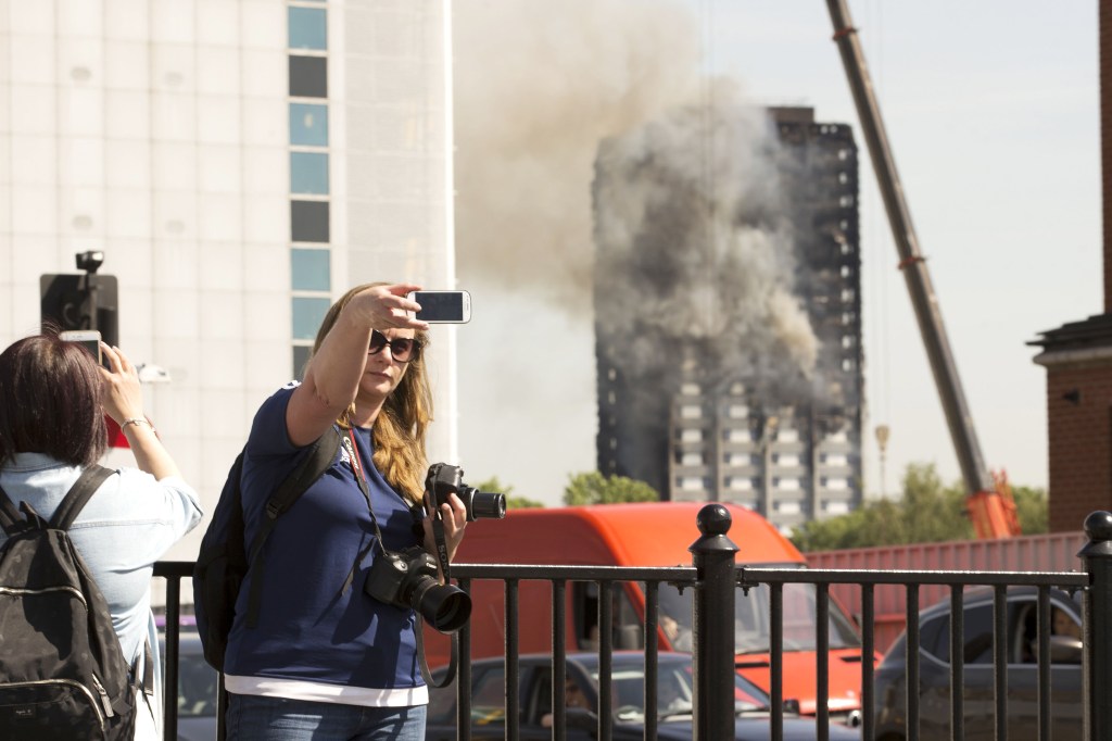 Una mujer toma una 'selfie' con la Torre Grenfell de fondo.