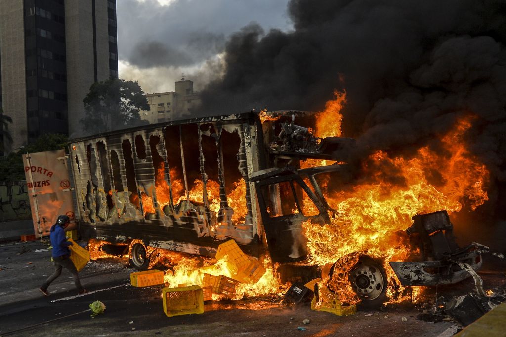 TOPSHOT - Anti-government protesters block the Francisco Fajardo highway in Caracas during a demonstration against Venezuelan President Nicolas Maduro on May 27, 2017. Demonstrations that got underway in late March have claimed the lives of 58 people, as opposition leaders seek to ramp up pressure on Venezuela's leftist president, whose already-low popularity has cratered amid ongoing shortages of food and medicines, among other economic woes. / AFP PHOTO / LUIS ROBAYO (Photo credit should read LUIS ROBAYO/AFP/Getty Images)