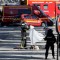 TOPSHOT - EDITORS NOTE: Graphic content / Rescuers cover with a white sheet the body of a man lying in a sealed off area of the Champs-Elysees avenue in Paris, on June 19, 2017 , after a car crashed into a police van before bursting into flames, with the driver being armed, probe sources said. A car burst into flames after it crashed into a police van on the Champs-Elysees avenue in Paris on June 19, police and investigators said, adding that the driver was armed and it appeared to be a "deliberate" act. Authorities said the driver was "most probably dead". / AFP PHOTO / Thomas SAMSON (Photo credit should read THOMAS SAMSON/AFP/Getty Images)