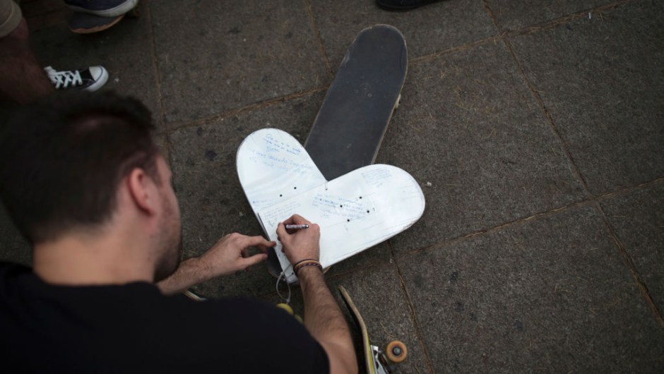 LAS ROZAS, SPAIN - JUNE 08: A skater writes a message on a heart shape skateboard during a vigil in tribute to Ignacio Echavarria, a victim of the London terror attack, outside of Las Rozas City Council on June 8, 2017 in Las Rozas, Madrid province, Spain. Spanish Ignacio Echevarria 39, was confirmed yesterday as one of the 8 victims of London Bridge terror attack. Echevarria is hailed as 'skateboard hero' after he confronted the three terrorists using his skateboard when they were attacking other members of the public with knives near Borough Market in London on June 3. All three terrorists were gunned down by police moments later. (Photo by Pablo Blazquez Dominguez/Getty Images)