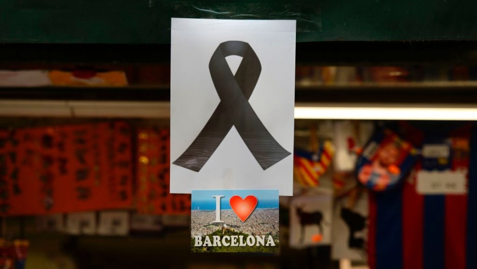 A picture taken on August 18, 2017 shows a black ribbon stuck above a postcard of Barcelona reading "I love Barcelona" both displayed on the window of a kiosk of the Rambla boulevard, a day after a van ploughed into the crowd, killing 13 persons and injuring over 100 on the Rambla in Barcelona. Drivers have ploughed on August 17, 2017 into pedestrians in two quick-succession, separate attacks in Barcelona and another popular Spanish seaside city, leaving 13 people dead and injuring more than 100 others. In the first incident, which was claimed by the Islamic State group, a white van sped into a street packed full of tourists in central Barcelona on Thursday afternoon, knocking people out of the way and killing 13 in a scene of chaos and horror. Some eight hours later in Cambrils, a city 120 kilometres south of Barcelona, an Audi A3 car rammed into pedestrians, injuring six civilians -- one of them critical -- and a police officer, authorities said. / AFP PHOTO / Josep LAGO (Photo credit should read JOSEP LAGO/AFP/Getty Images)