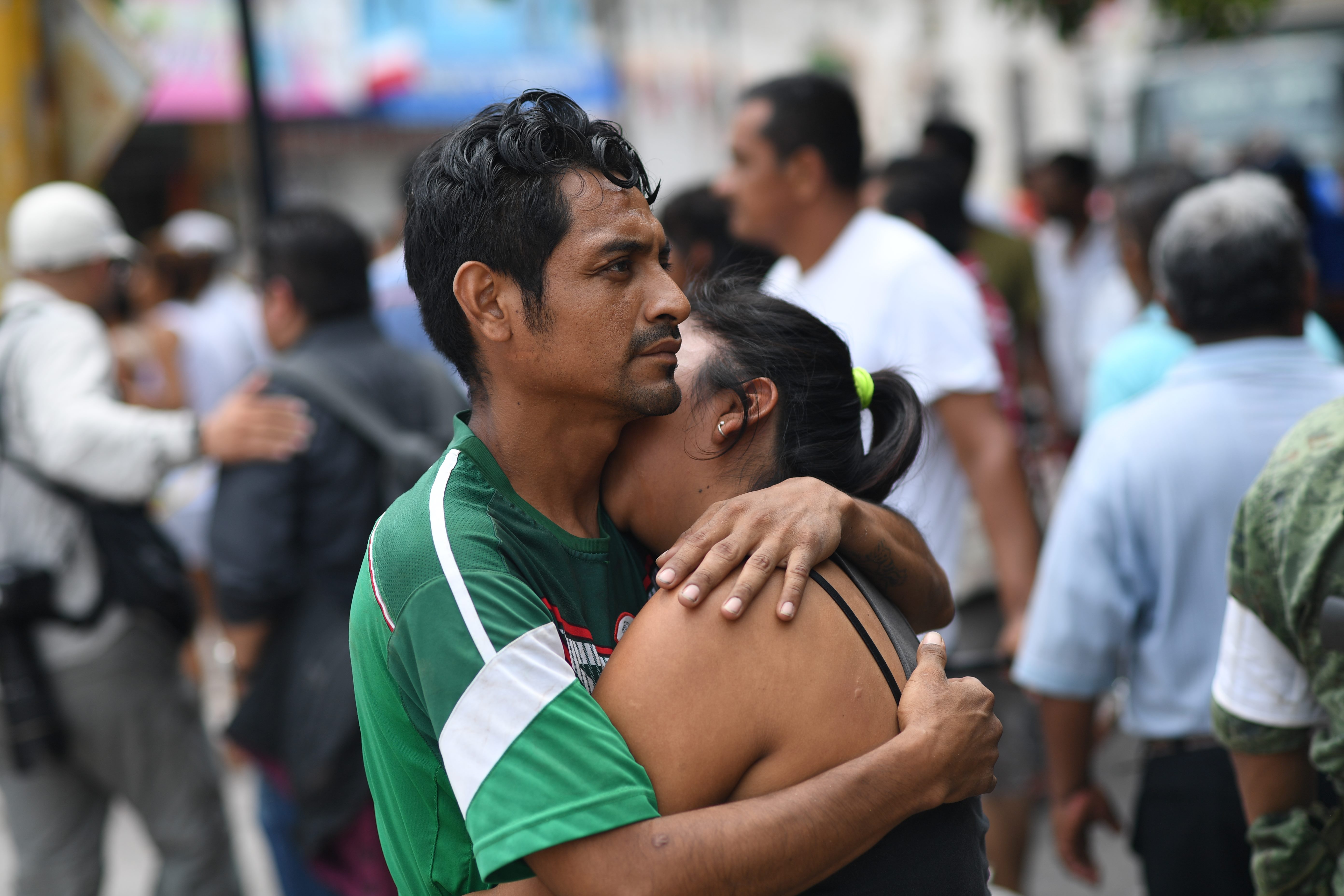 A couple embraces on September 8, 2017 in Juchitan de Zaragoza, state of Oaxaca, where buildings collapsed after an 8.2 earthquake that hit Mexico's Pacific coast overnight. Mexico's most powerful earthquake in a century killed at least 35 people, officials said, after it struck the Pacific coast, wrecking homes and sending families fleeing into the streets. / AFP PHOTO / Pedro PARDO (Photo credit should read PEDRO PARDO/AFP/Getty Images)