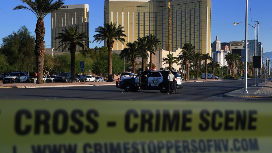 Crime scene tape surrounds the Mandalay Hotel (background) after a gunman killed at least 50 people and wounded more than 200 others when he opened fire on a country music concert in Las Vegas, Nevada on October 2, 2017. Police said the gunman, a 64-year-old local resident named as Stephen Paddock, had been killed after a SWAT team responded to reports of multiple gunfire from the 32nd floor of the Mandalay Bay, a hotel-casino next to the concert venue. / AFP PHOTO / Mark RALSTON (Photo credit should read MARK RALSTON/AFP/Getty Images)