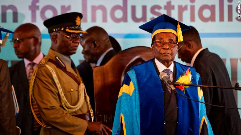 Zimbabwe's President Robert Mugabe, center-right, arrives to preside over a student graduation ceremony at Zimbabwe Open University on the outskirts of Harare, Zimbabwe Friday, Nov. 17, 2017. Mugabe is making his first public appearance since the military put him under house arrest earlier this week. (AP Photo/Ben Curtis)