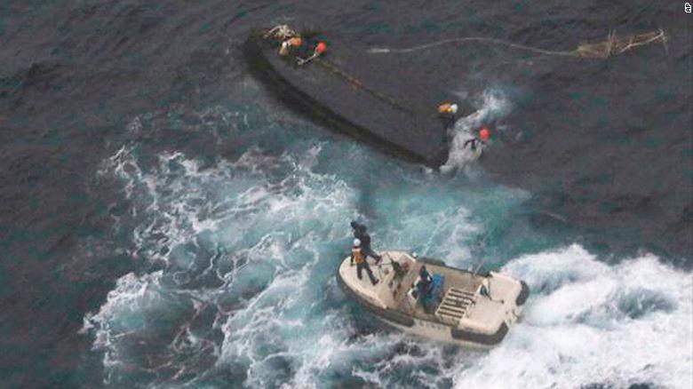 In this Wednesday, Nov. 15, 2017, photo provided by the 9th Regional Japan Coast Guard Headquarters, a boat of the Japan Coast Guard approaches a capsized wooden vessel, top, for a rescue operation in the water off Noto peninsula, northern coast of Japan. Three crew members rescued from the capsized boat are North Koreans, and Tokyo is arranging their return home. The area is a rich fishing ground where poachers from North Korea and China have been spotted. (9th Regional Japan Coast Guard Headquarters via AP)