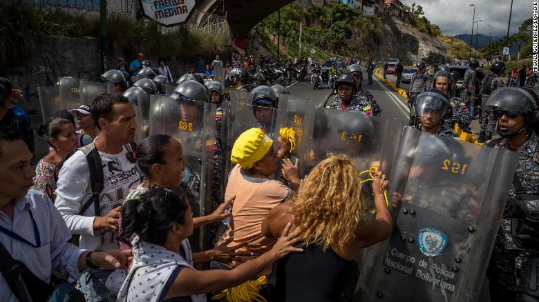 epa06408476 A group of people protest in front of members of the Bolivarian National Police (PNB) in Caracas, Venezuela, 28 December 2017. The protests over the shortage, the scarcity of food and the lack of domestic gas and water continued today in Caracas and other cities of the country, according to local media information. EPA-EFE/MIGUEL GUTI???RREZ