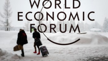 Two people leave the Congress Centre under snow ahead of the opening of the World Economic Forum (WEF) 2018 annual meeting, on January 22, 2018 in Davos, eastern Switzerland. US President Donald Trump's participation at the World Economic Forum in Davos, Switzerland next week could be thrown into question now that the federal government has partially shut down over budget wrangling, the White House said on January 20. / AFP PHOTO / Fabrice COFFRINI (Photo credit should read FABRICE COFFRINI/AFP/Getty Images)