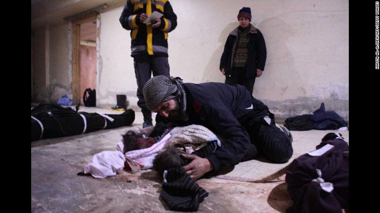 Un hombre llora sobre su hijo, que murió en los ataques aéreos de Mesraba.